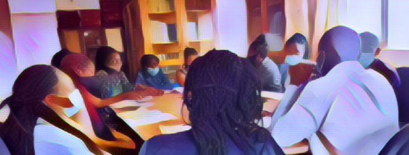 Many students sitting at table wearing masks